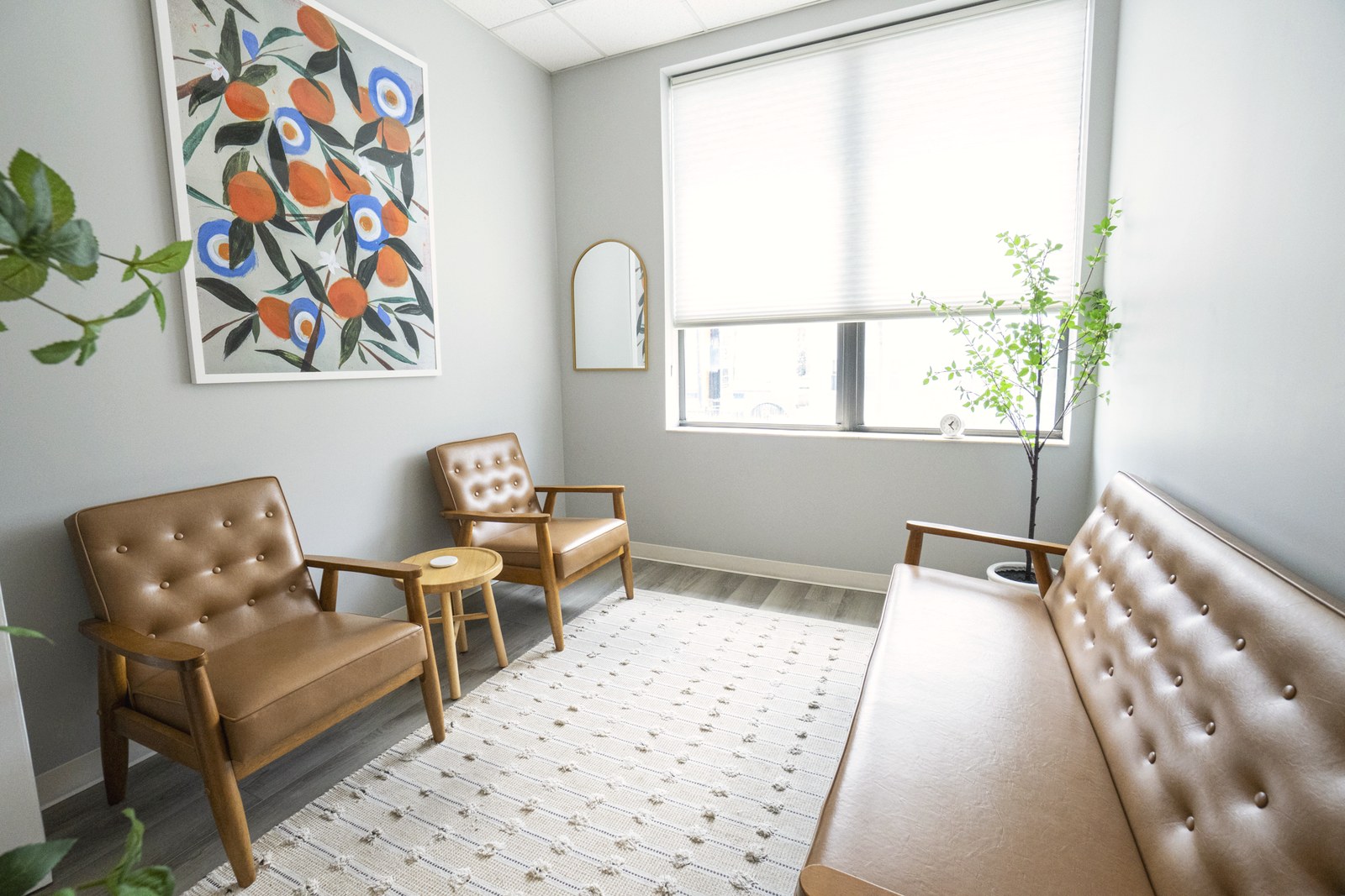 Sunlit therapy room with orange wall art and leather chairs at Lincoln Park Therapy Group in Chicago