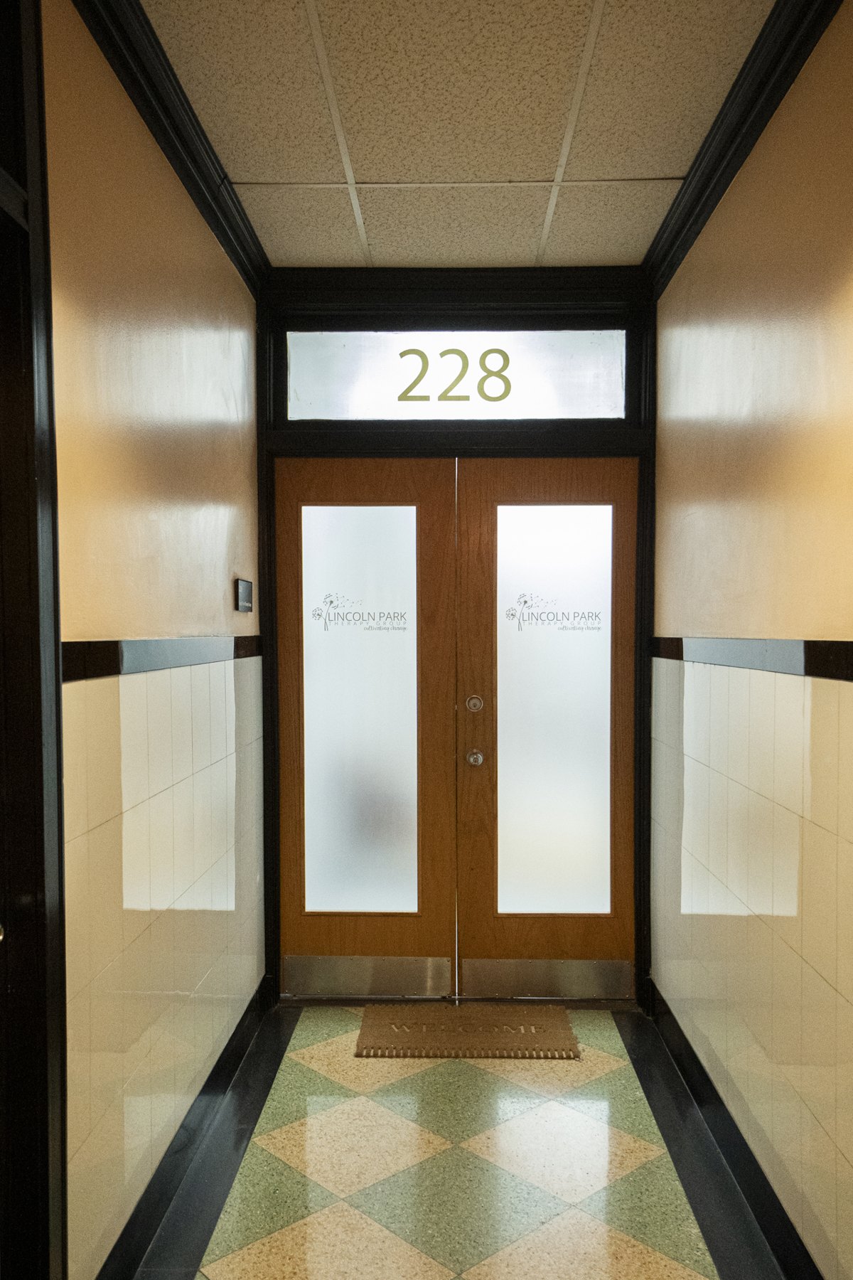 Double doors to Suite 228 at our Lakeview office, with the Lincoln Park Therapy Group logo on the frosted glass